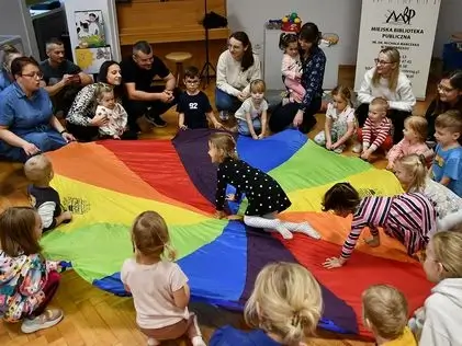 Zdjęcie poglądowe z nocy bibliotek. Dzieci bawią się z rodzicami.